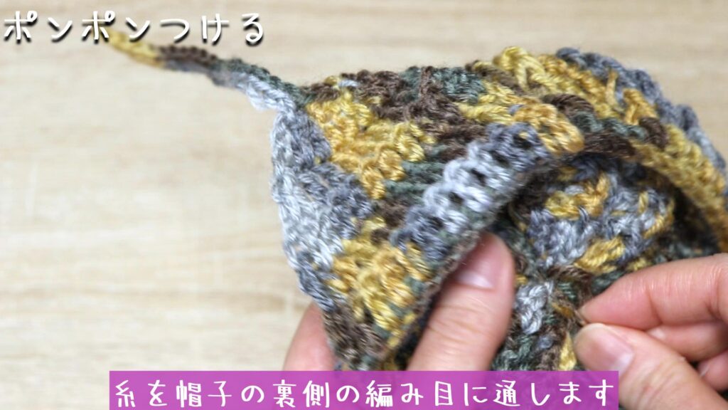裏側で2回固結びをして、糸を帽子の裏側の編み目に通します。
