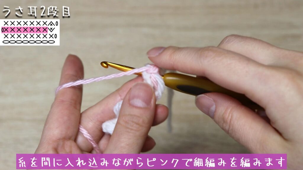 糸を間に入れ込みながらピンクで細編みを編みます。
