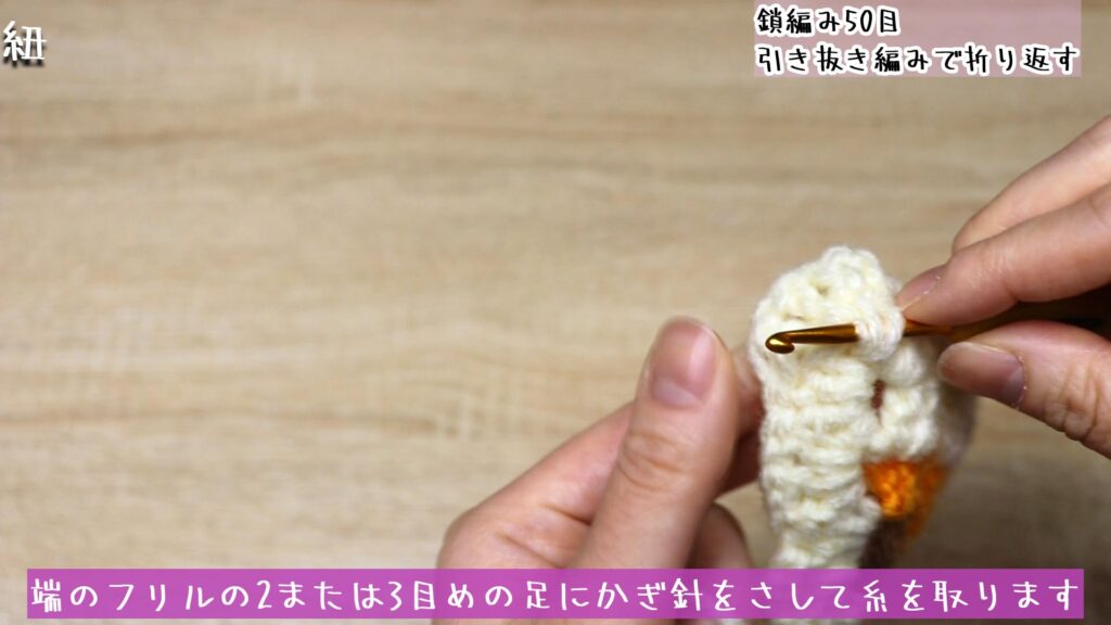 端のフリルの2または3目めの足にかぎ針をさして糸を取ります