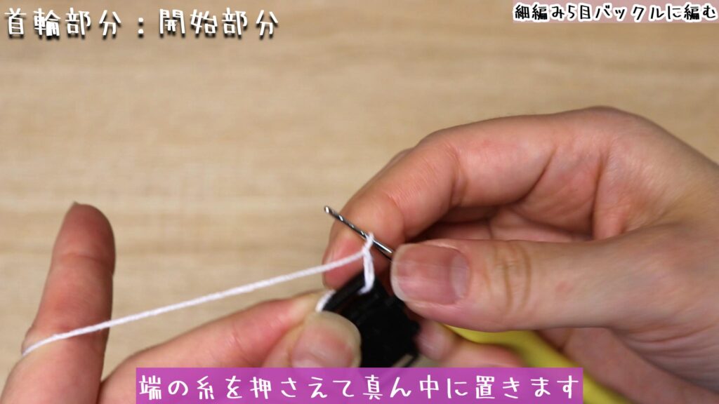 端の糸を押さえて真ん中に置きます。