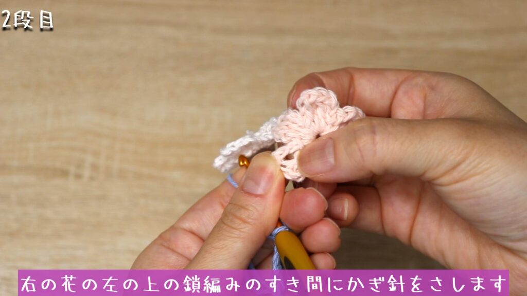 右の花の左の上の鎖編みのすき間にかぎ針をさします