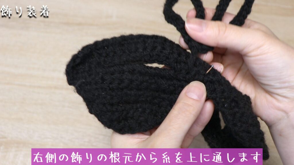 右側の飾りの根元から糸を上に通します