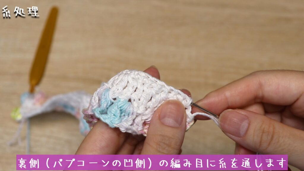 裏側（パプコーンの凹側）の編み目に糸を通します
