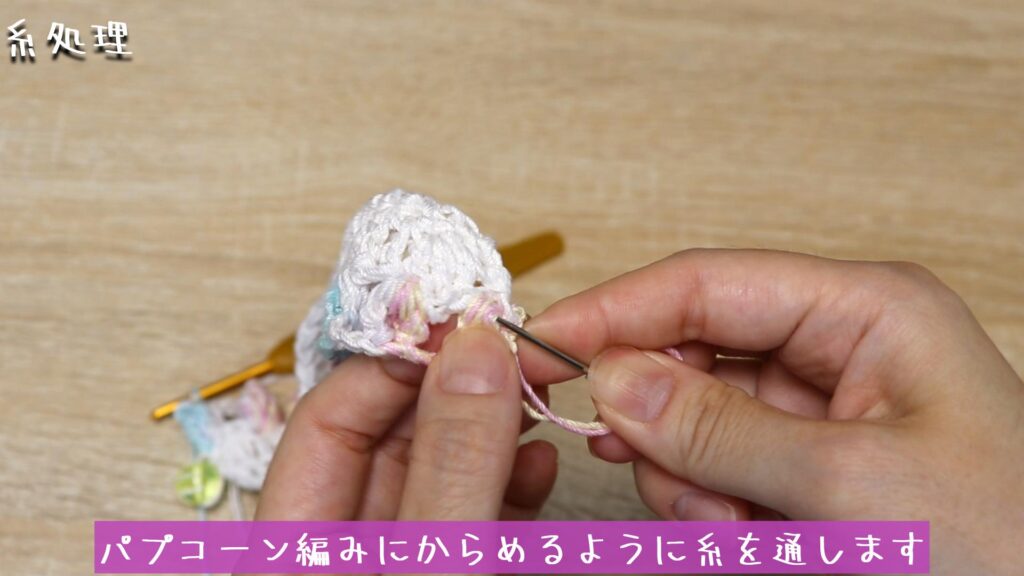 パプコーン編みにからめるように糸を通します。